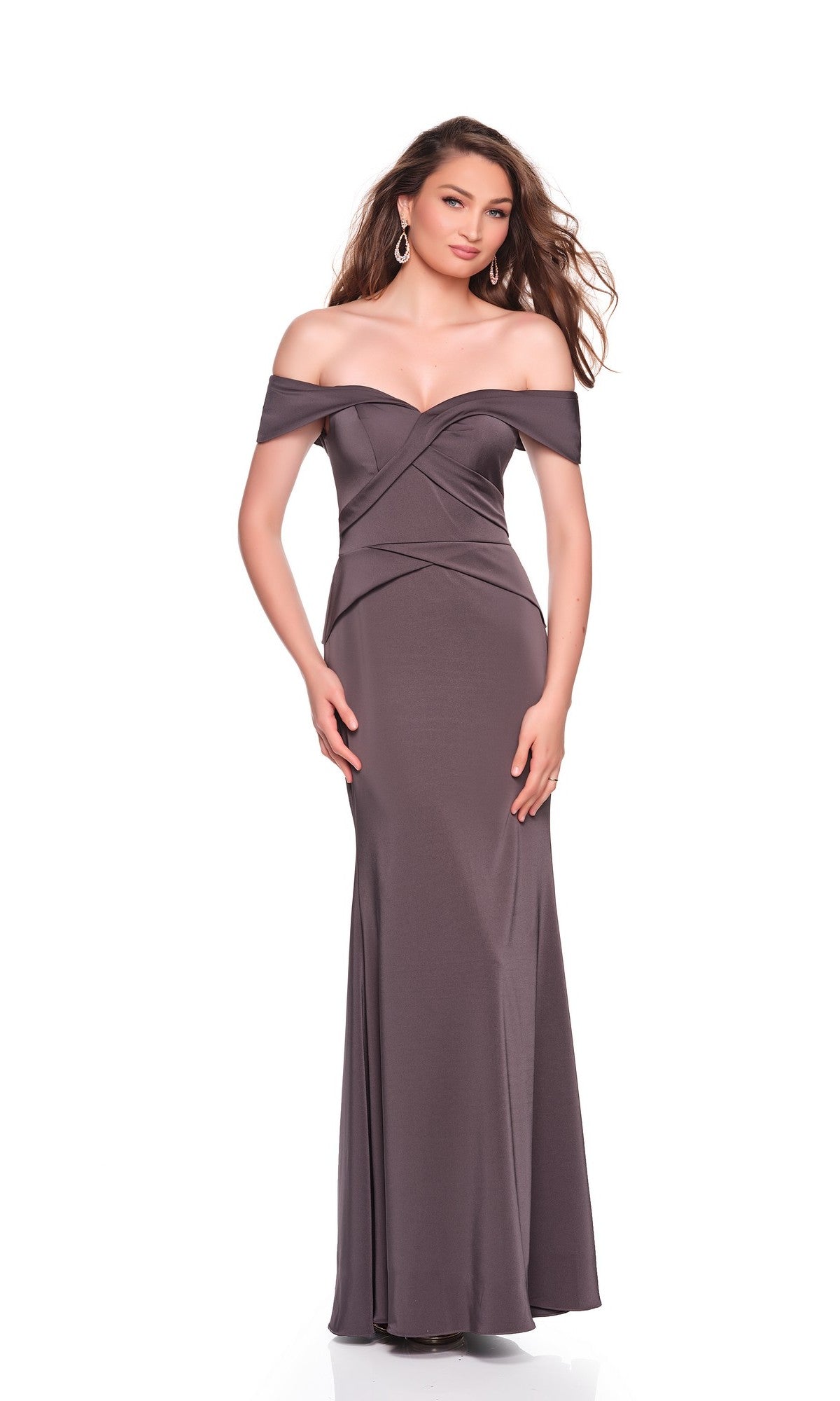 A woman wearing the Dave and Johnny 12571 long prom dress with a sweetheart neckline and off-the-shoulder design, paired with hoop earrings, stands against a white background.